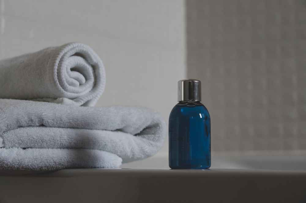 blue glass bottle beside white towel