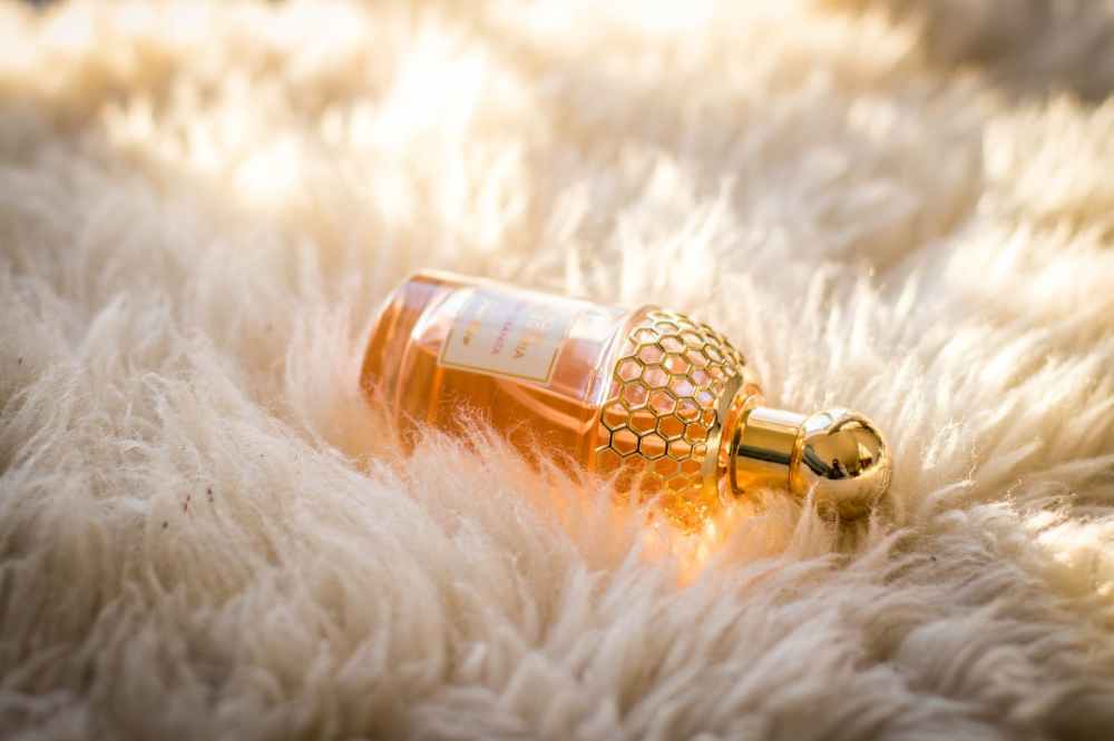 clear perfume bottle on white fur textile
